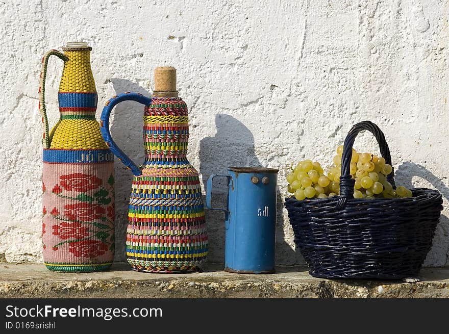 Color bottles with basket and white grapes. Color bottles with basket and white grapes