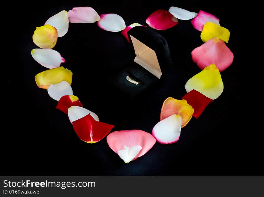 Heart shape made from rose petals and diamond ring. Heart shape made from rose petals and diamond ring