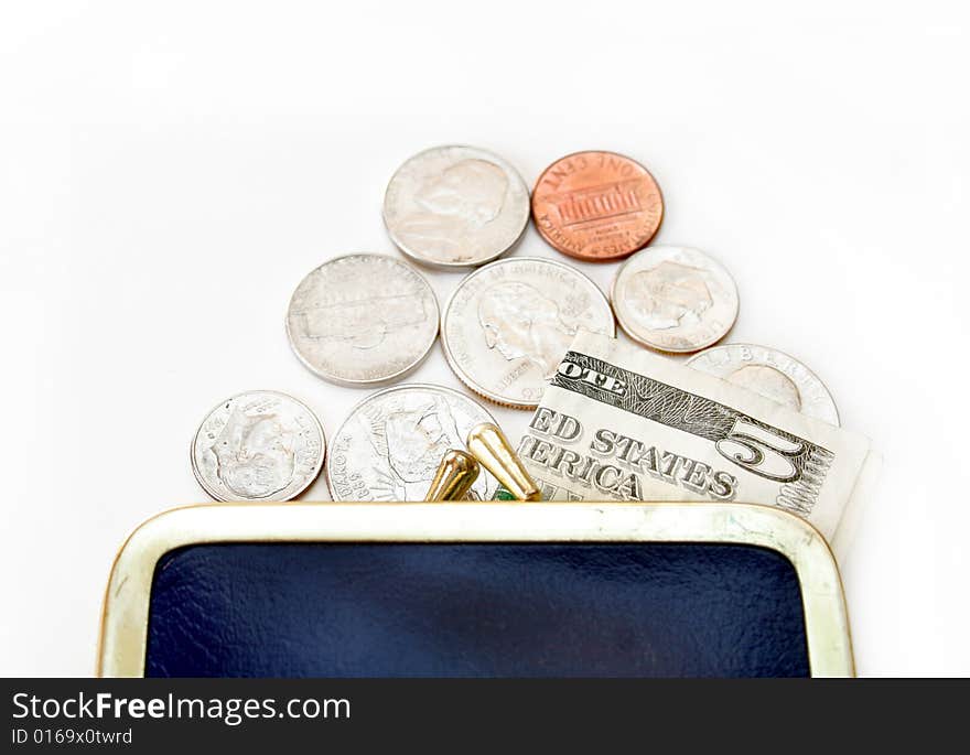 Loose change and a five dollar bill spilling out of a change purse onto an isolated background. Loose change and a five dollar bill spilling out of a change purse onto an isolated background.