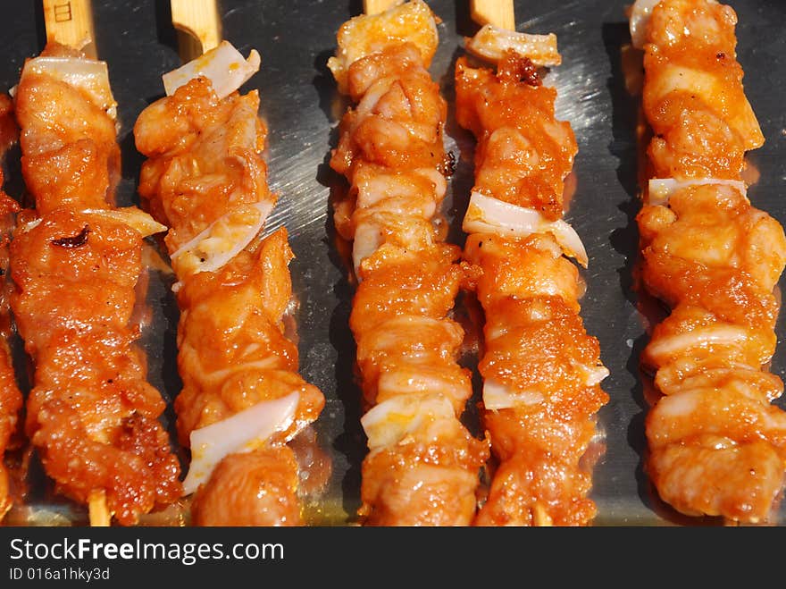 The strings of chicken meat and gristle in the steel tray.