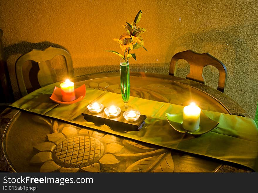 A table with candles and flowers, in an intimate corner of the home. A table with candles and flowers, in an intimate corner of the home