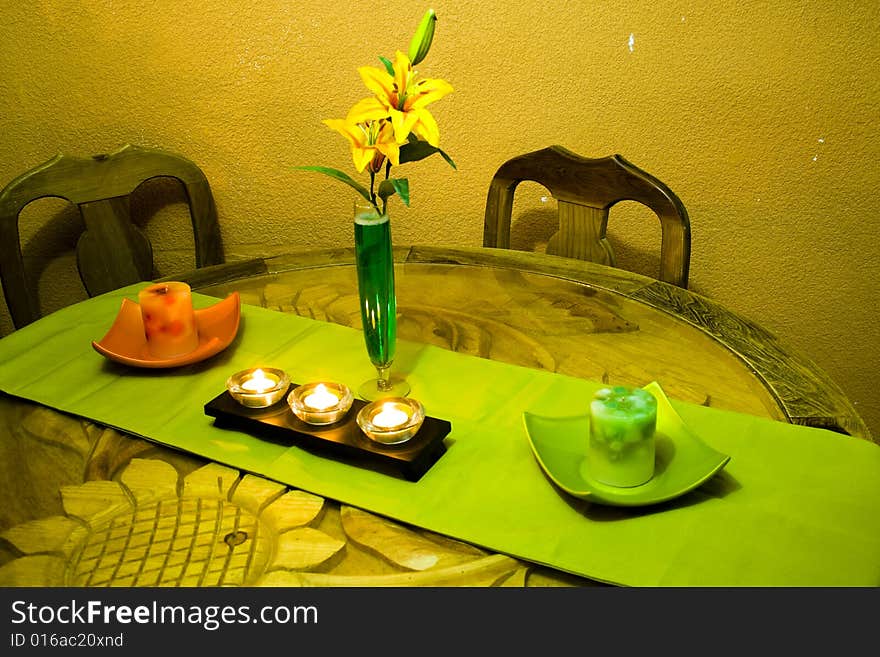 A table with candles and flowers, in an intimate corner of the home. A table with candles and flowers, in an intimate corner of the home