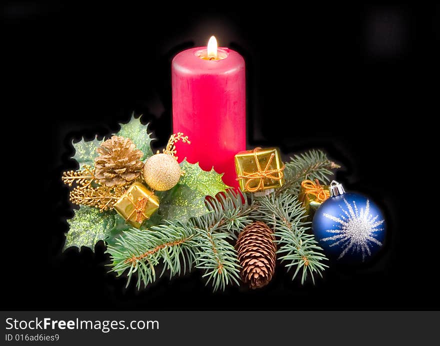 Red celebratory burning candle and New Year's ornaments with blue sphere on black background