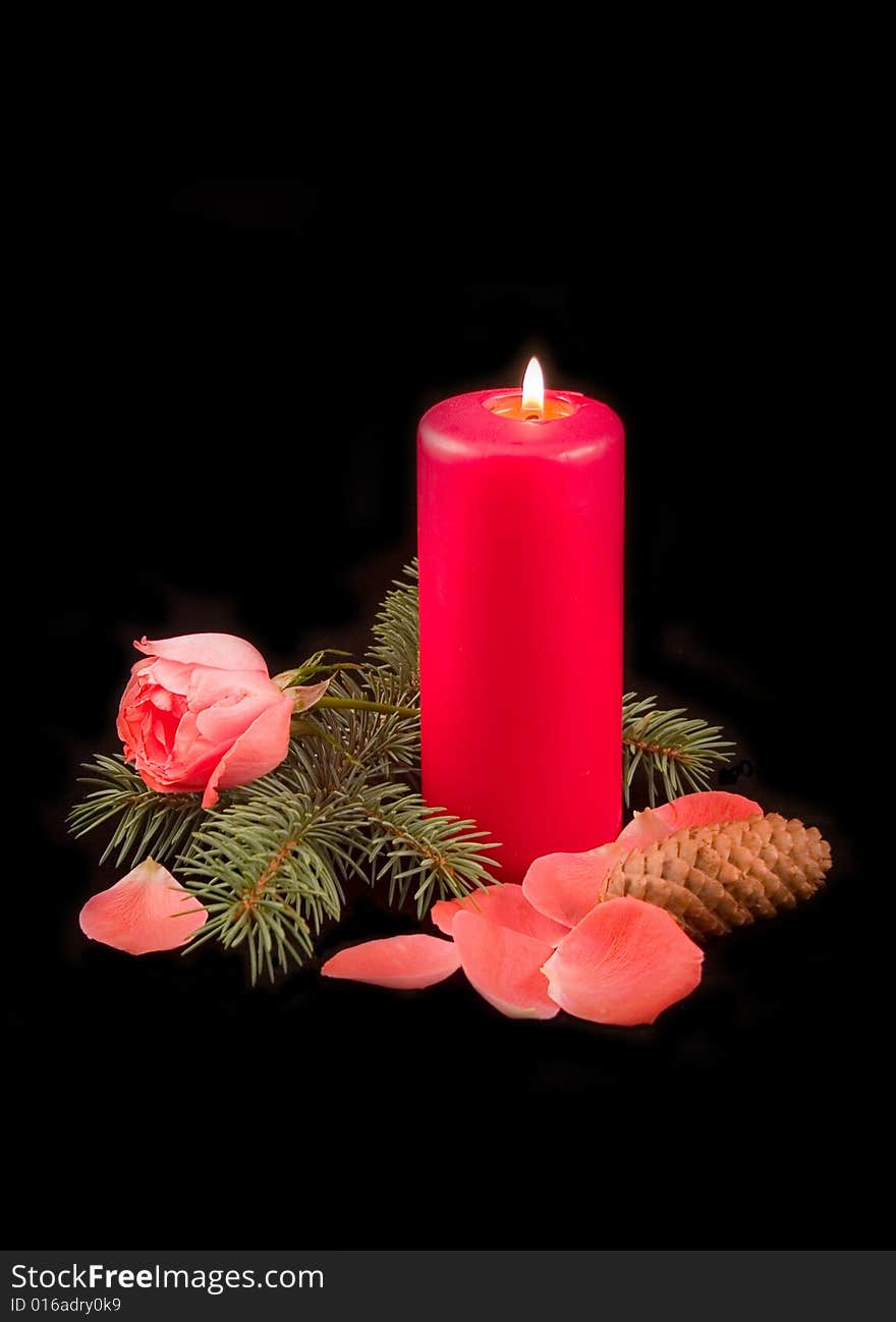 Candle red with flame and scarlet rose with petals on a black background