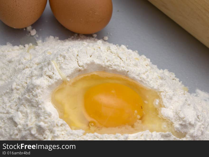 Flour and eggs on a kitchen table for preparation a dough