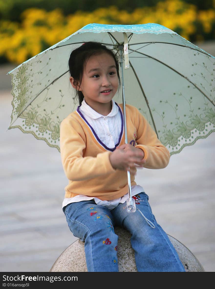 The smiling girl with a umbrella in a park .