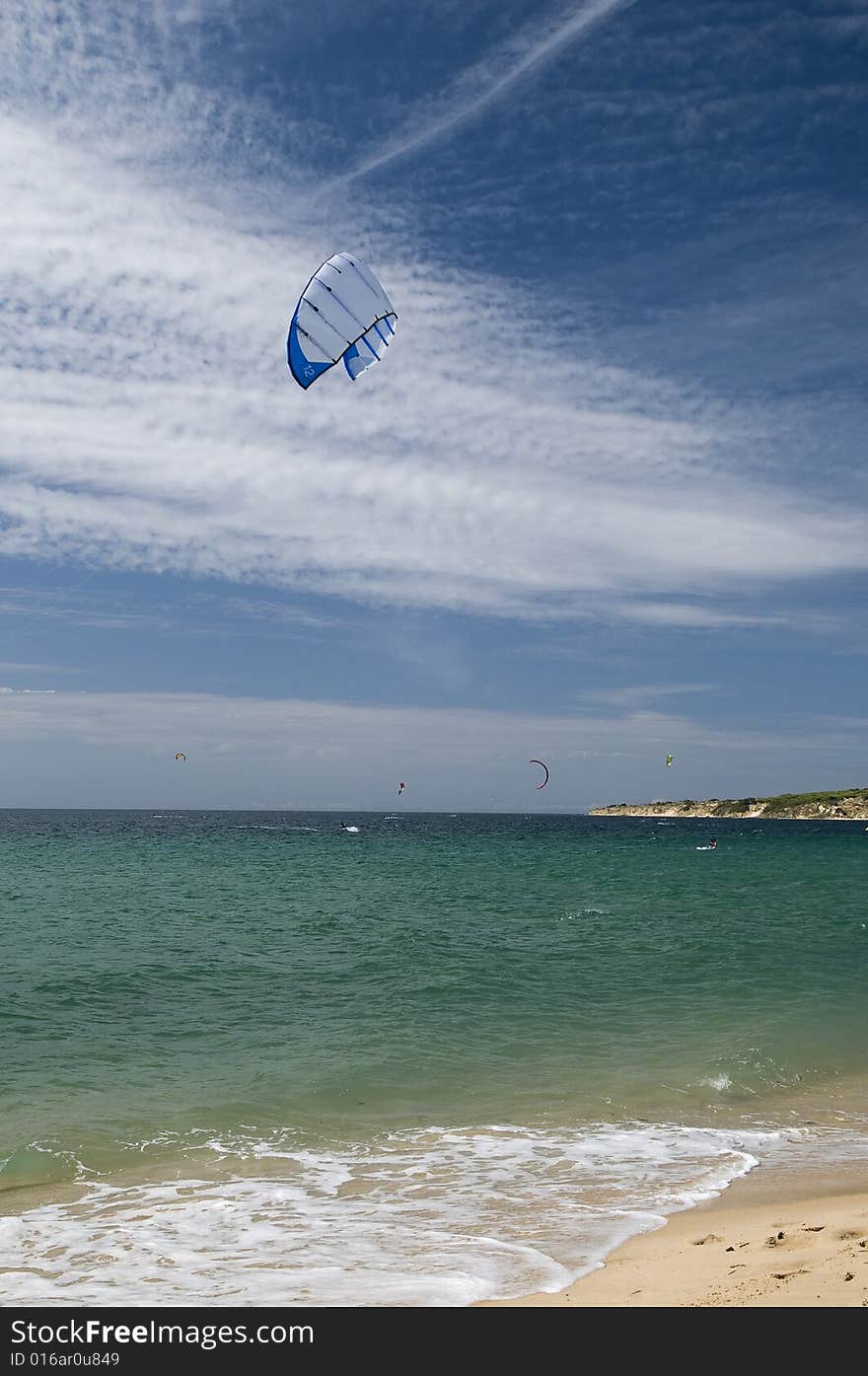 Kitesurfing near  Tarifa blue sky and sandy beach