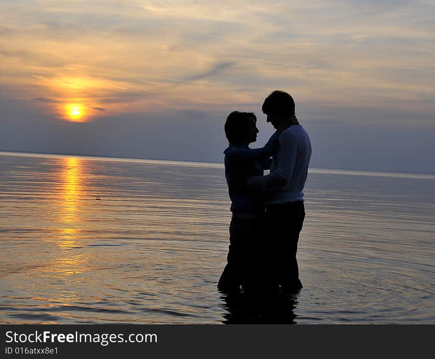 Two silhouettes of in love pair on a background sunset. Two silhouettes of in love pair on a background sunset