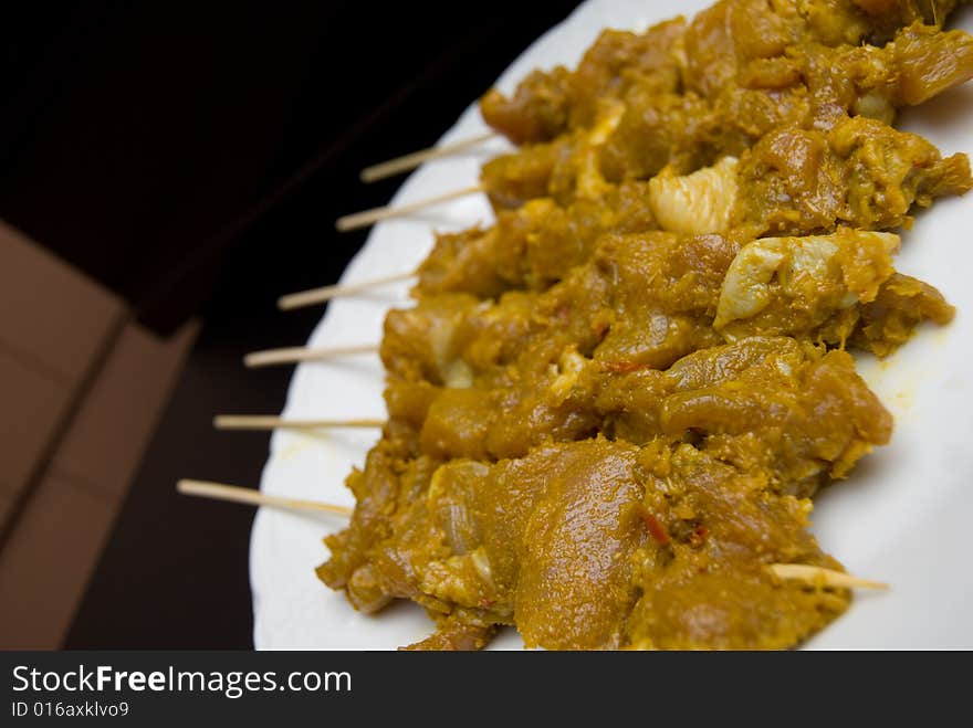 Close up of chicken satay skewers that are about to be barbequed