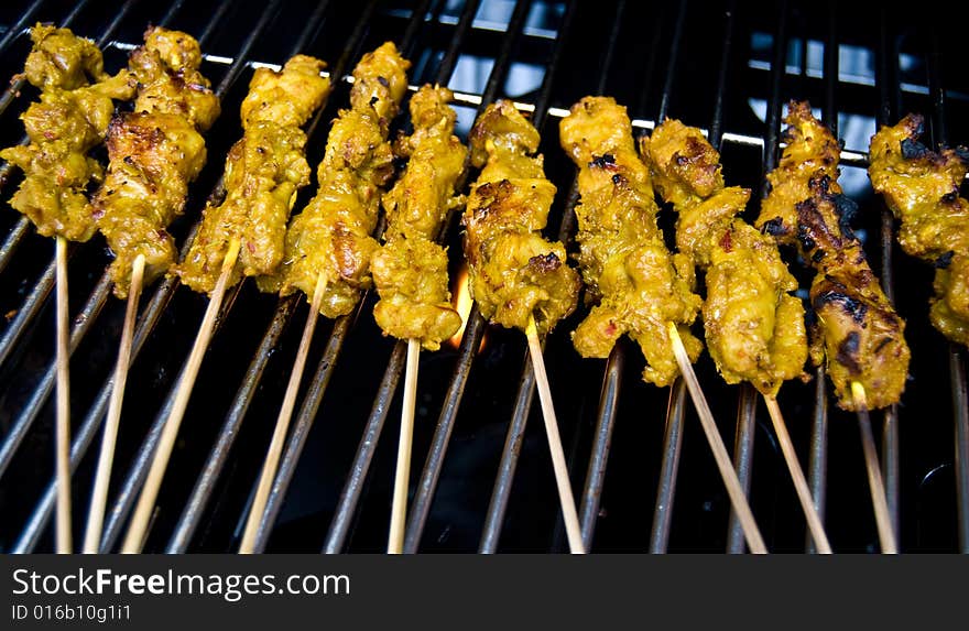 Chicken satay being bbqed on a grill. Chicken satay being bbqed on a grill