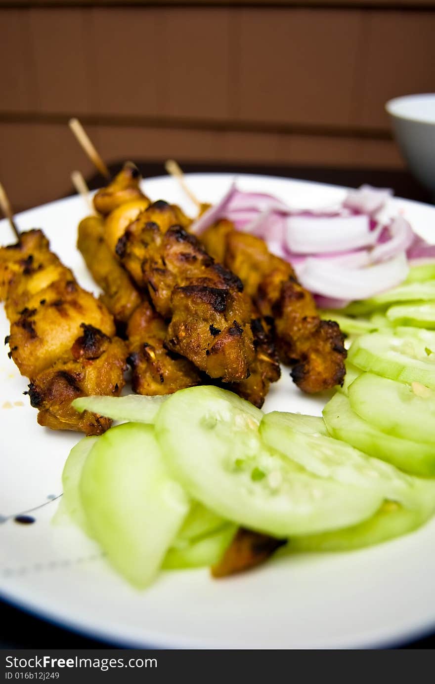 Chicken Satays that have been barbequed, served with sliced onions and cucumber. Chicken Satays that have been barbequed, served with sliced onions and cucumber.