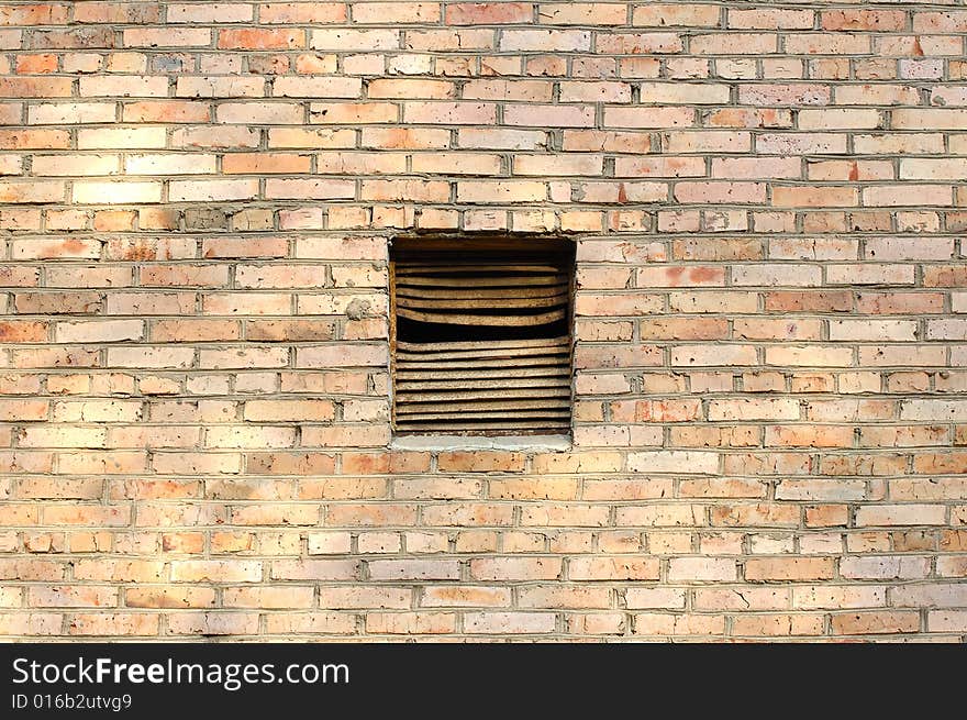 Ventilation window on brick wall.