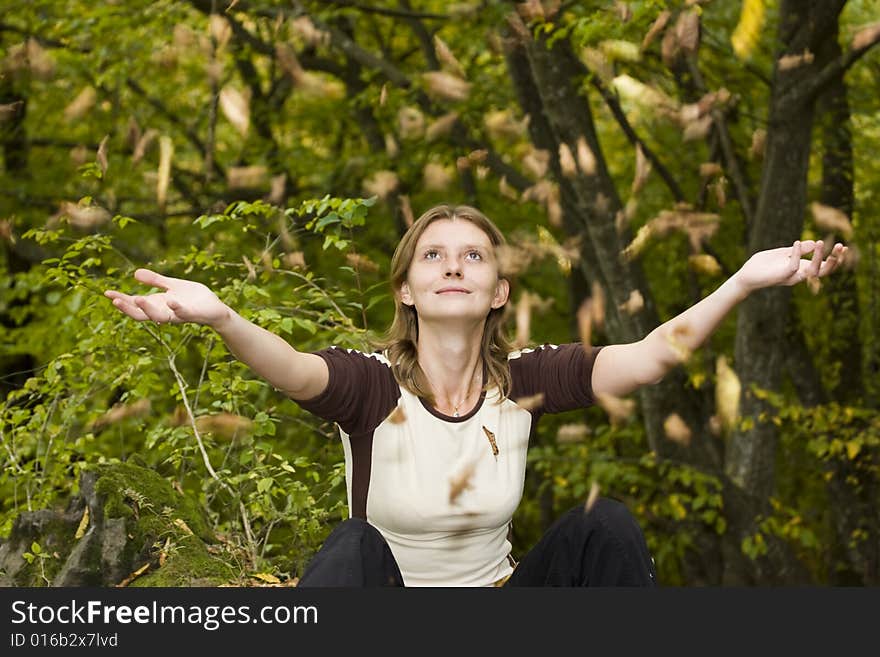 Girl relaxing in autumn park with falling leaves. Girl relaxing in autumn park with falling leaves