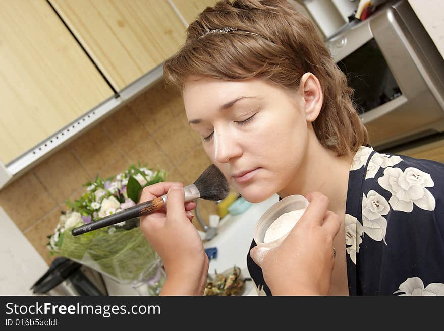 A cosmetologist applies face make-up for a woman. A cosmetologist applies face make-up for a woman