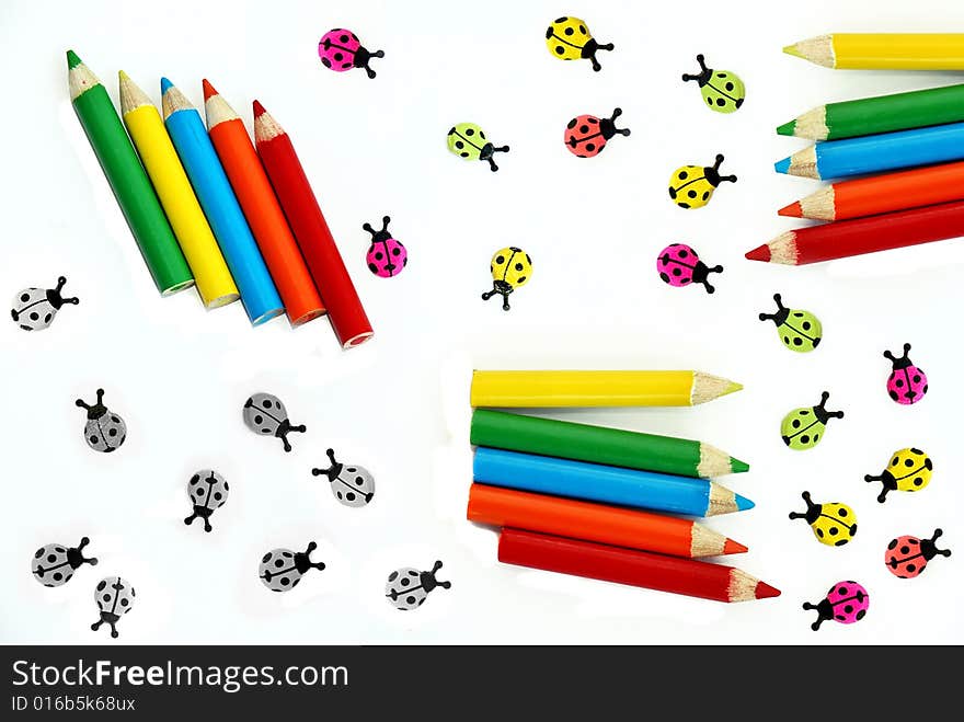 Various small crayons and ladybirds isolated over white. Various small crayons and ladybirds isolated over white