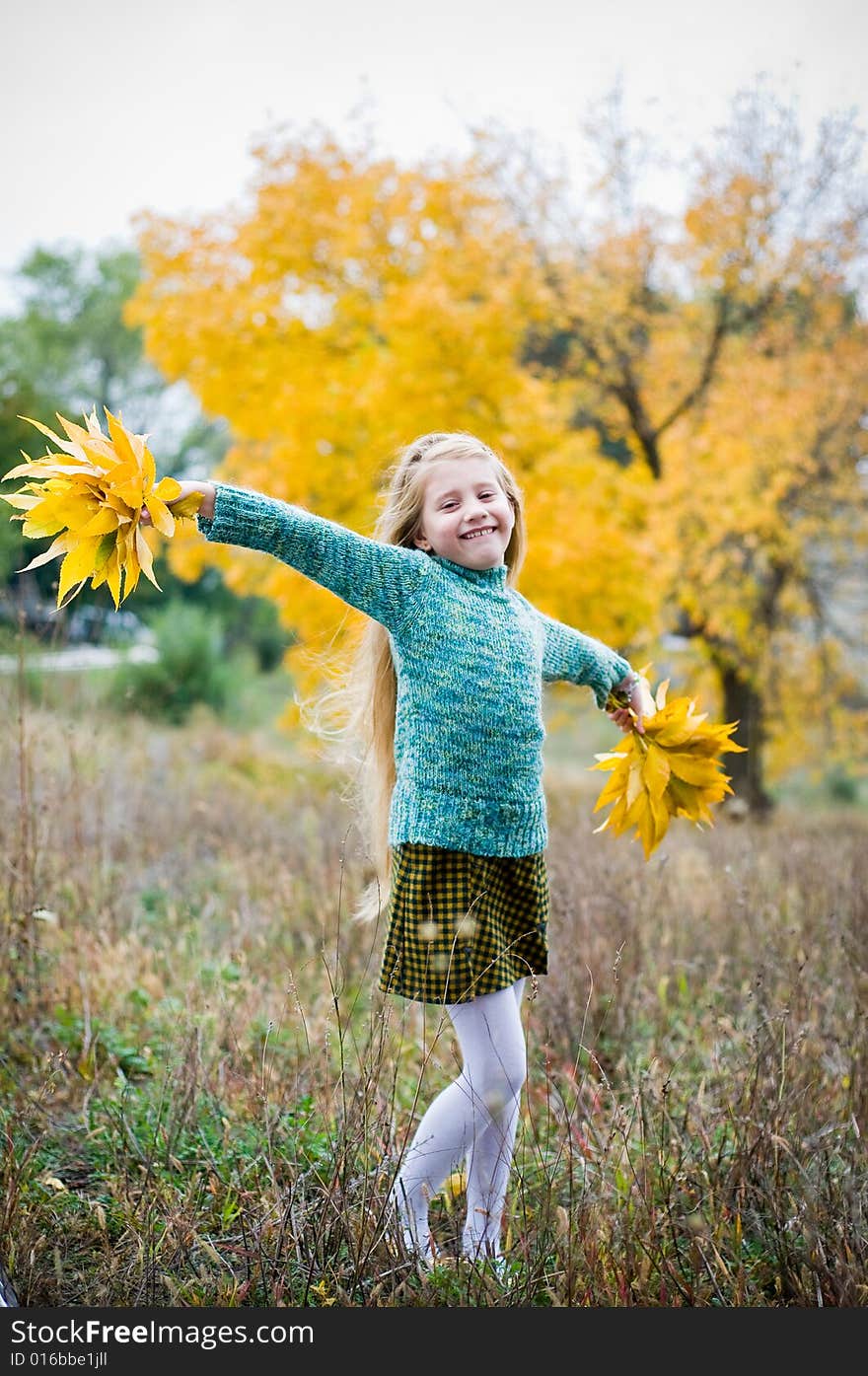 Cute girl with hands open over autumn background