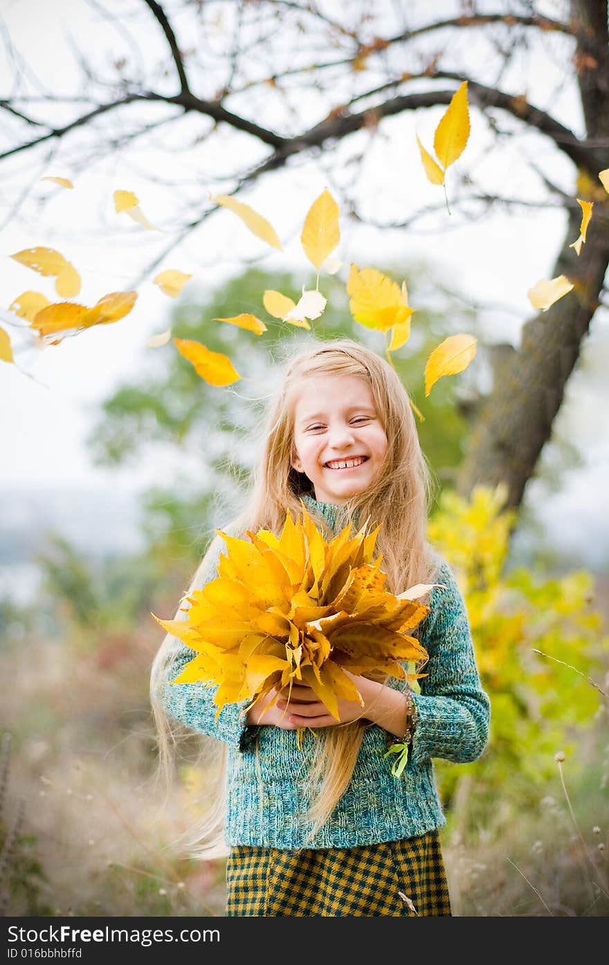 Smiling little girl with autumn leaves