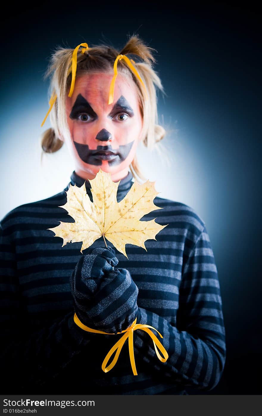 Jack-o-lantern girl with tied hands, focus on leaf