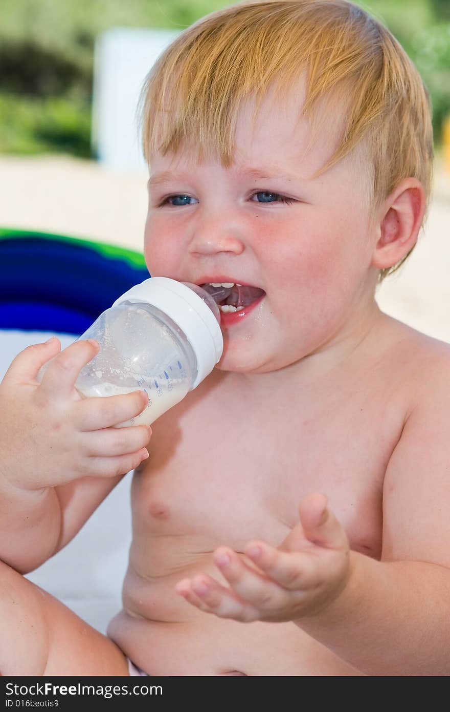 Portrait of the laughing child with a bottle of milk. Portrait of the laughing child with a bottle of milk