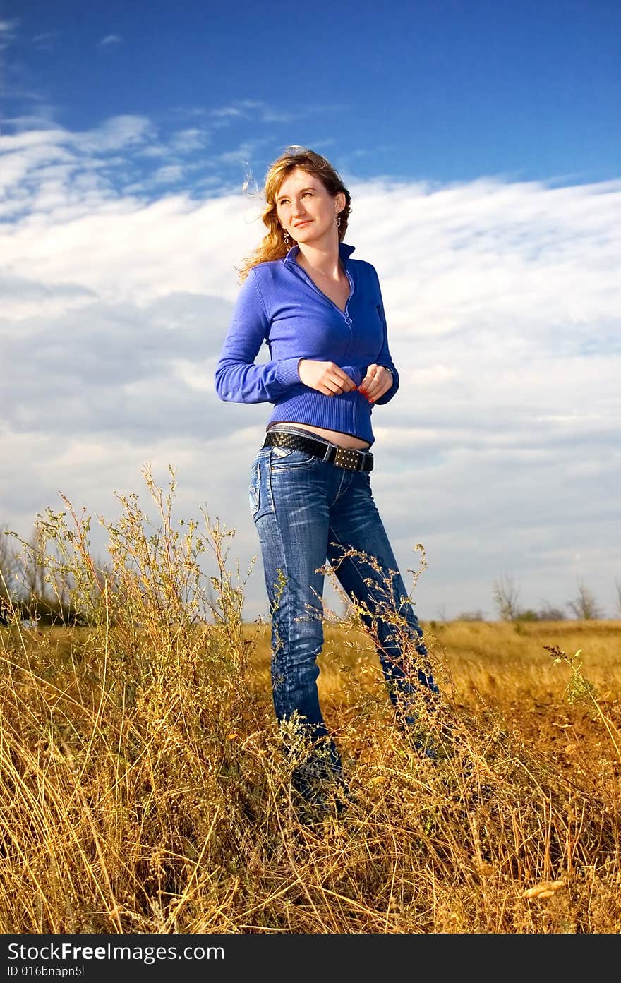 The girl in an autumn field against the sky. The girl in an autumn field against the sky