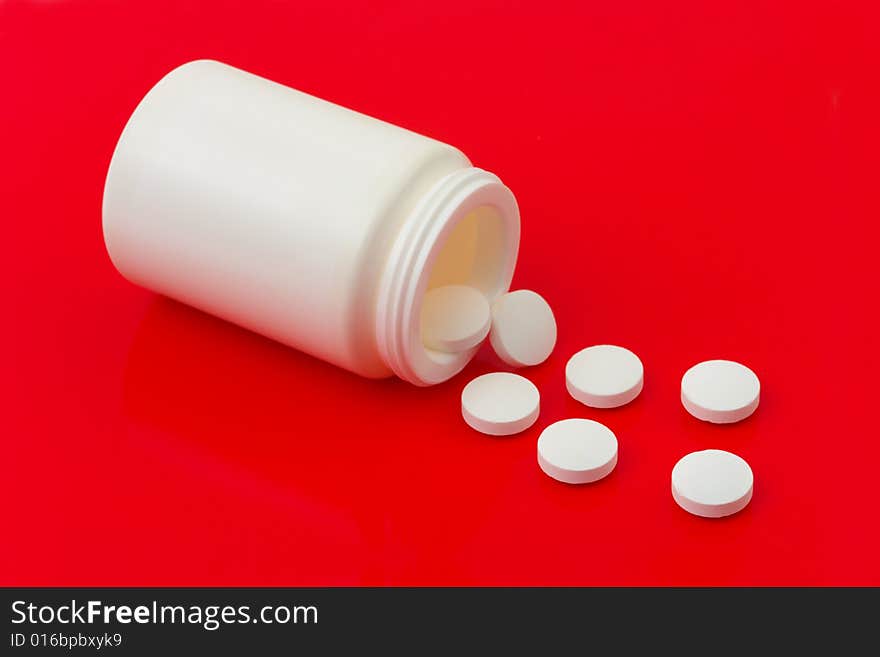 Bottle of pills on red background