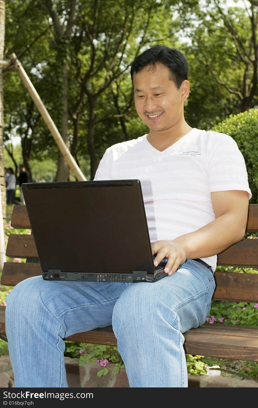 A young man using a laptop outdoors