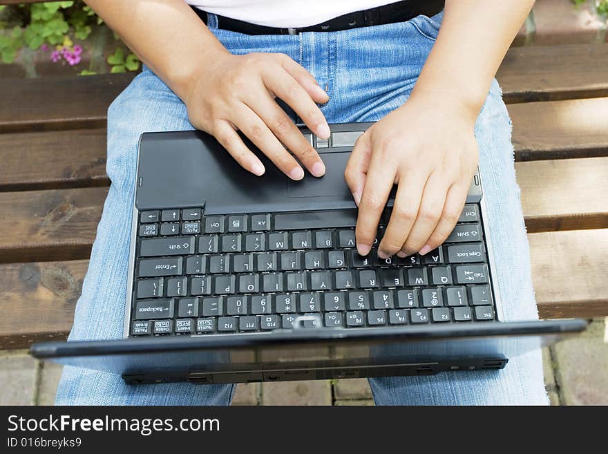 A young man using a laptop in the park