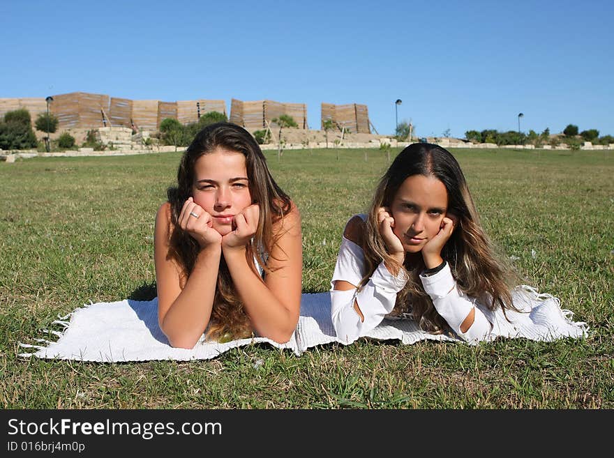 Two beautiful young women relaxing in the grass. Two beautiful young women relaxing in the grass