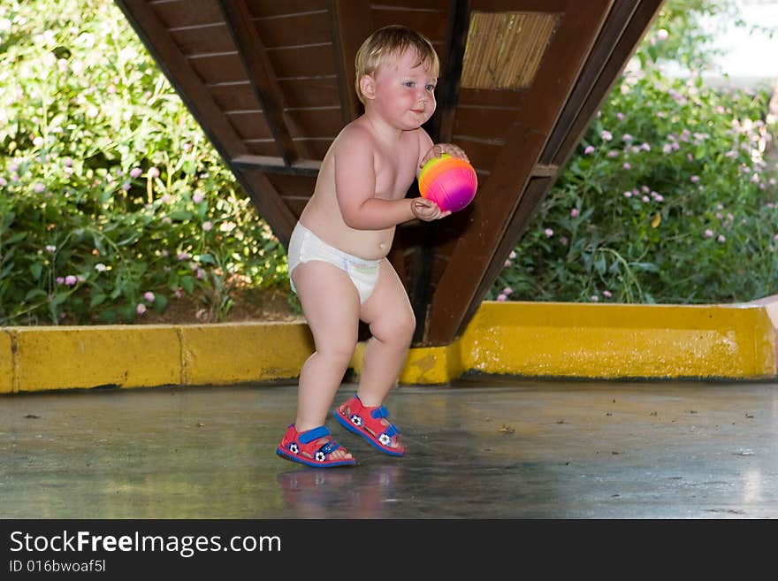 Small child plays a ball on a children's playground