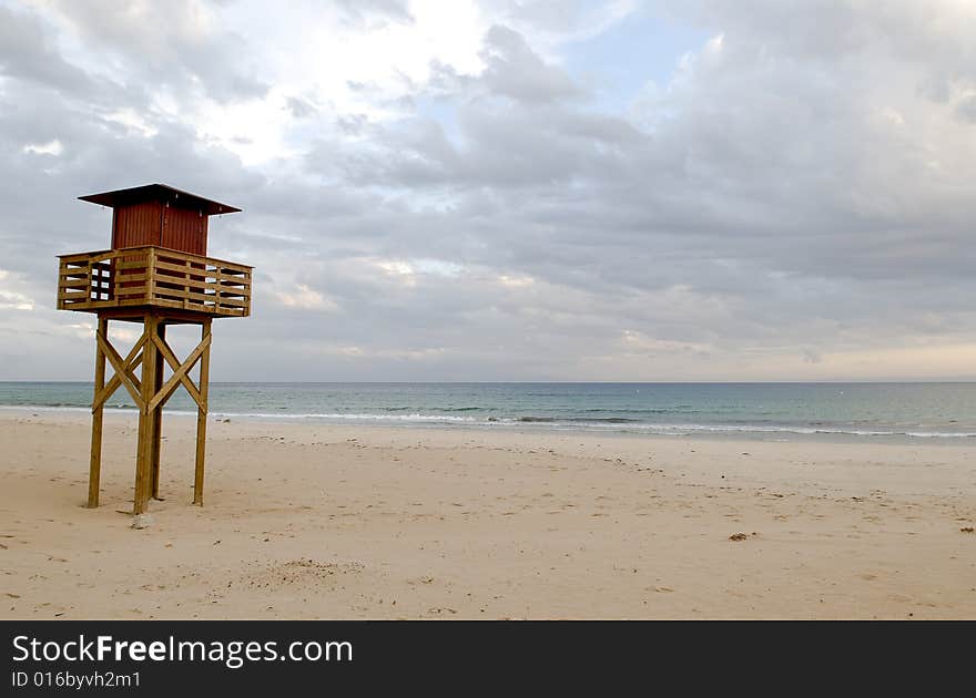 Empty beach with watchtower sunset