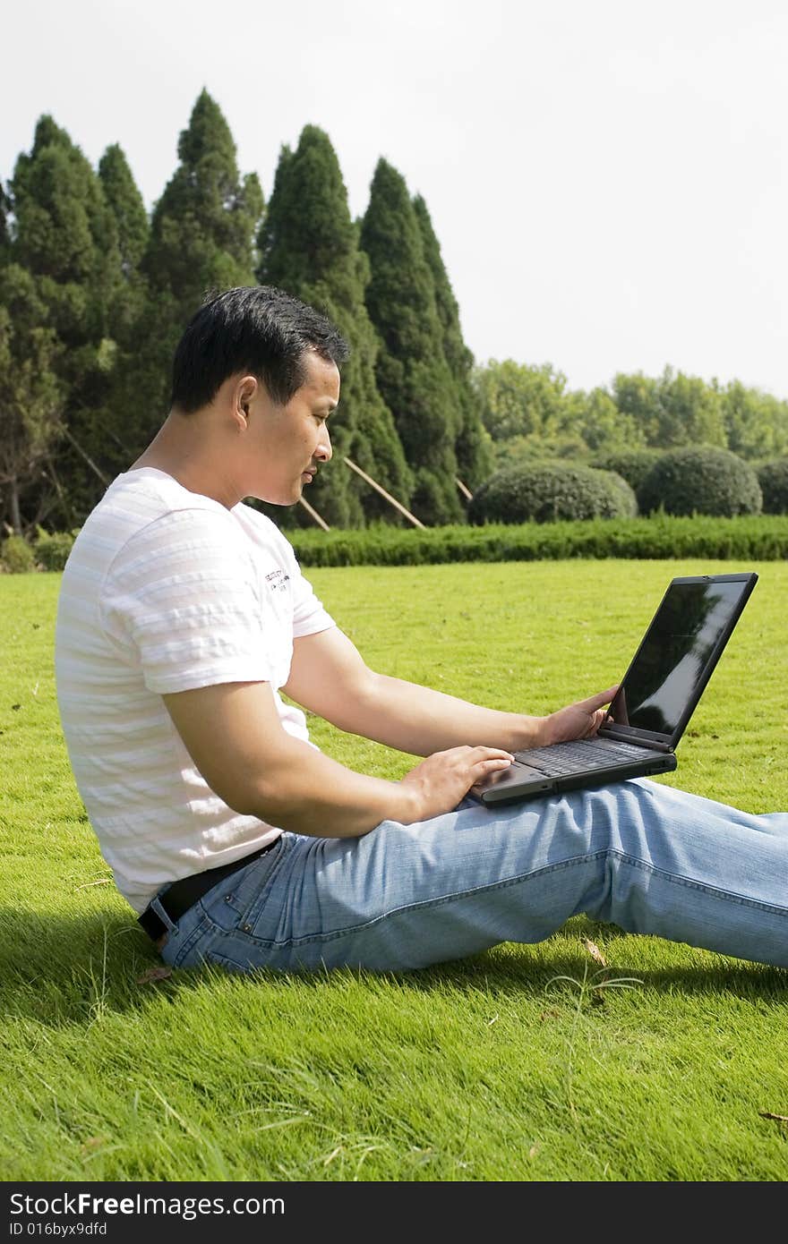 A young man using a laptop outdoors