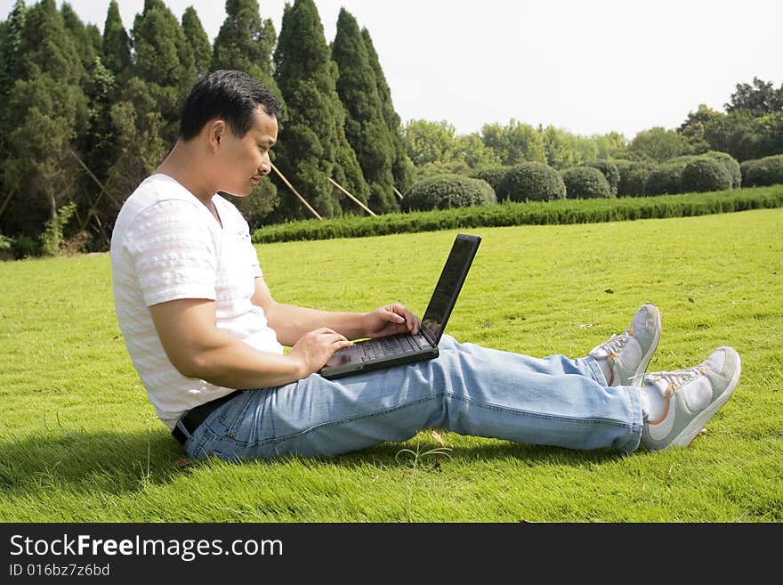 A young man using a laptop outdoors