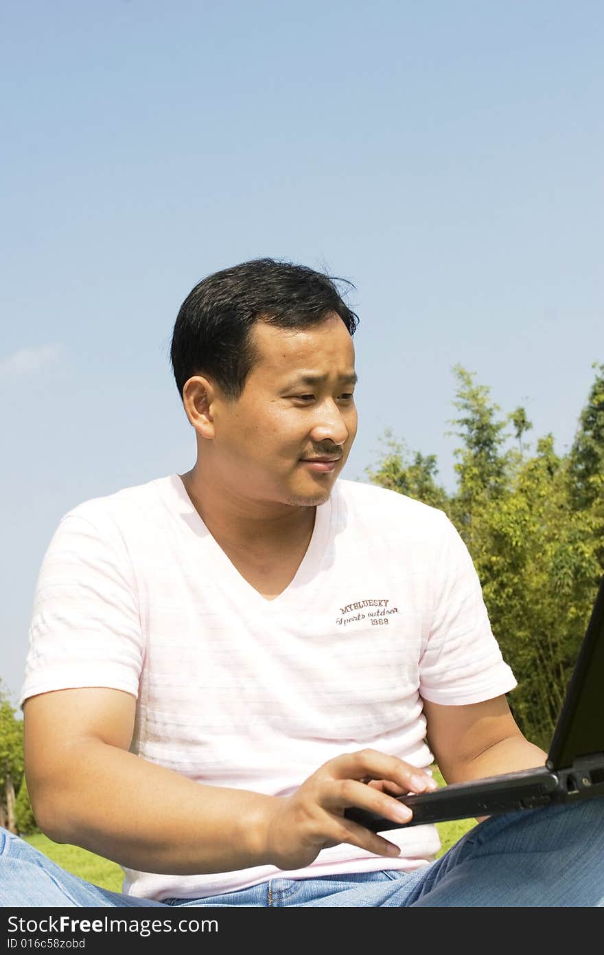 A young man using a laptop outdoors