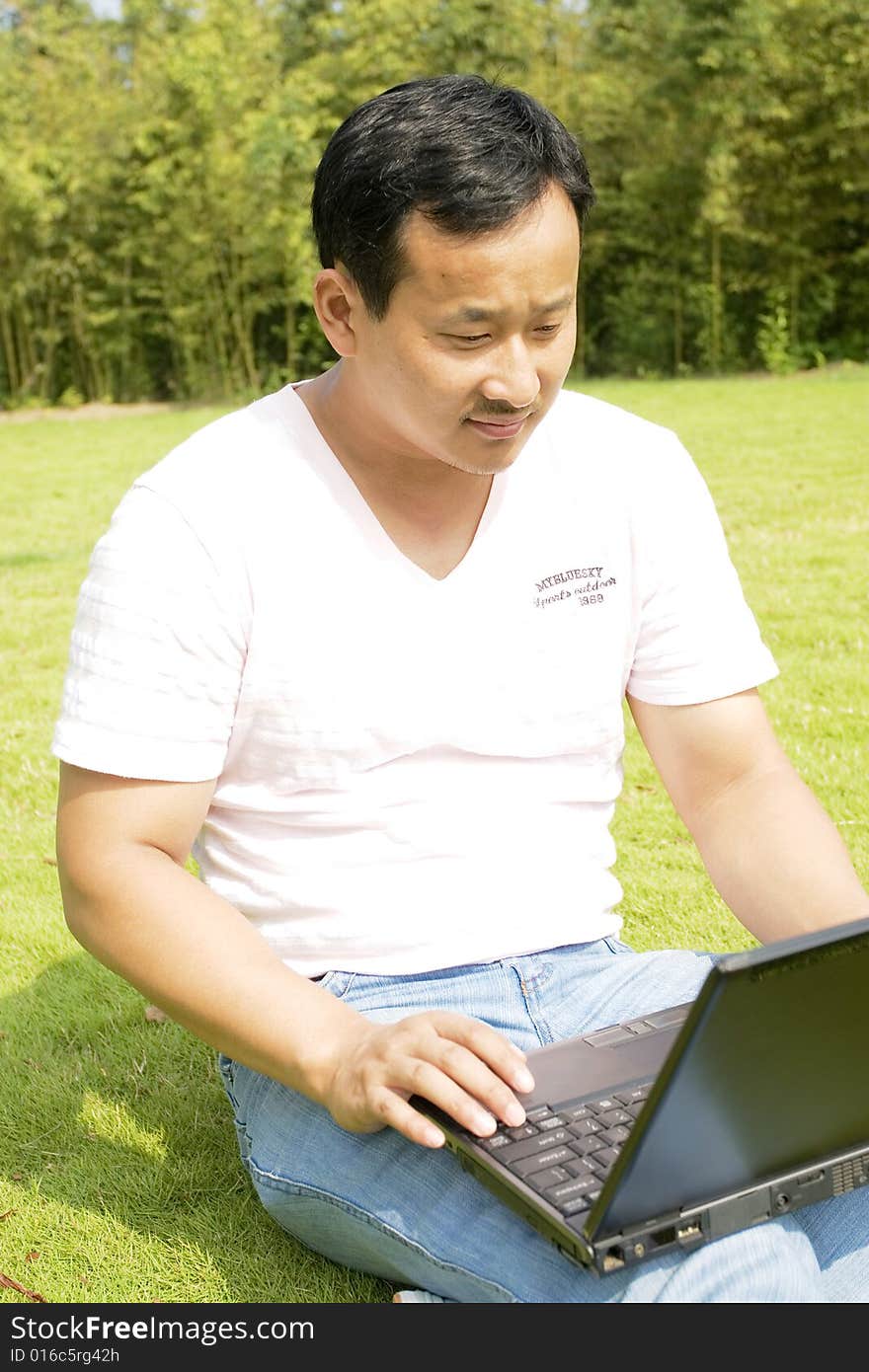 A young man using a laptop outdoors