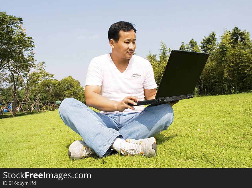 A young man using a laptop outdoors