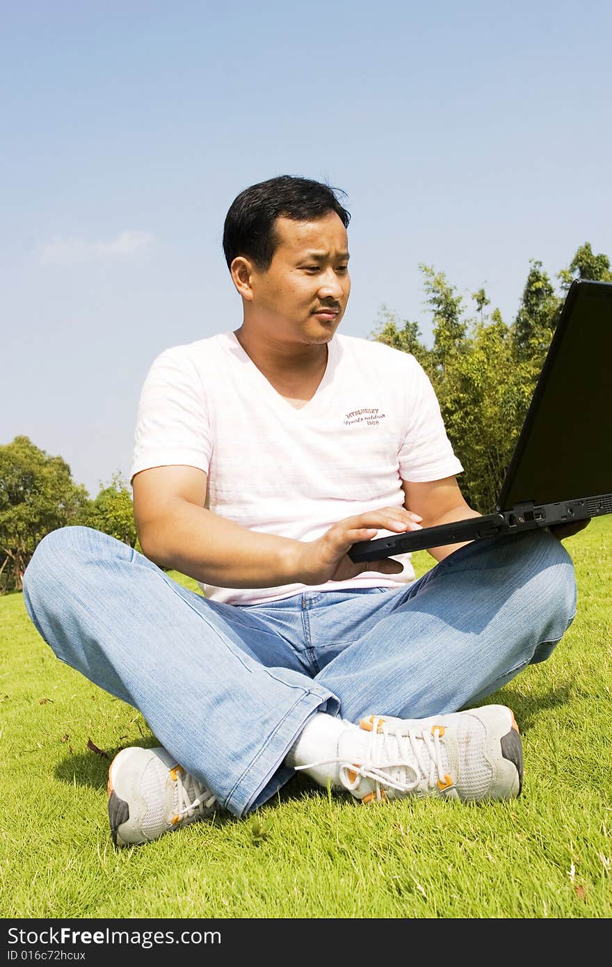 A young man using a laptop outdoors