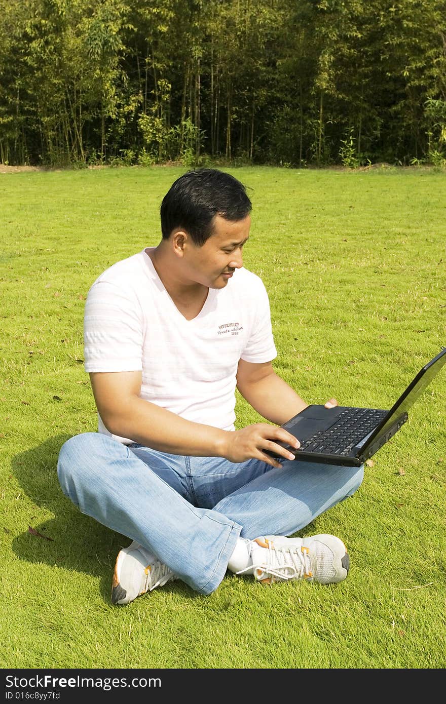 A young man using a laptop outdoors