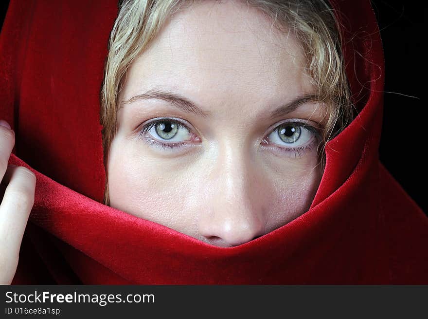 Beautiful young blond woman in closeup with shawl over her face