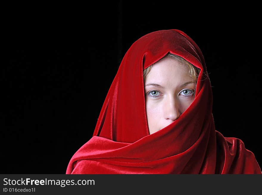 Beautiful young blond woman in closeup with shawl over her face