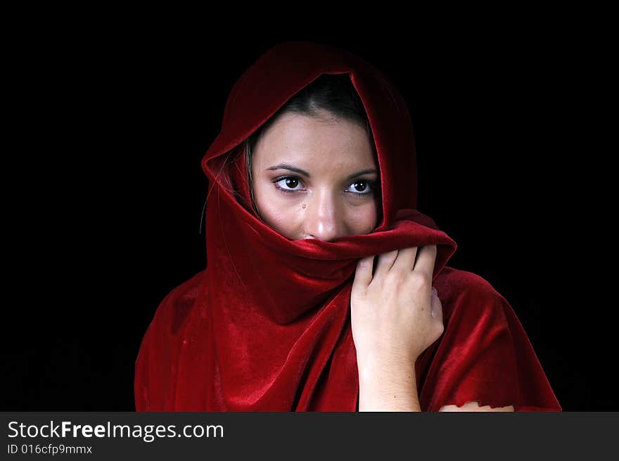 Beautiful young brunette woman in closeup with red shawl over face. Beautiful young brunette woman in closeup with red shawl over face