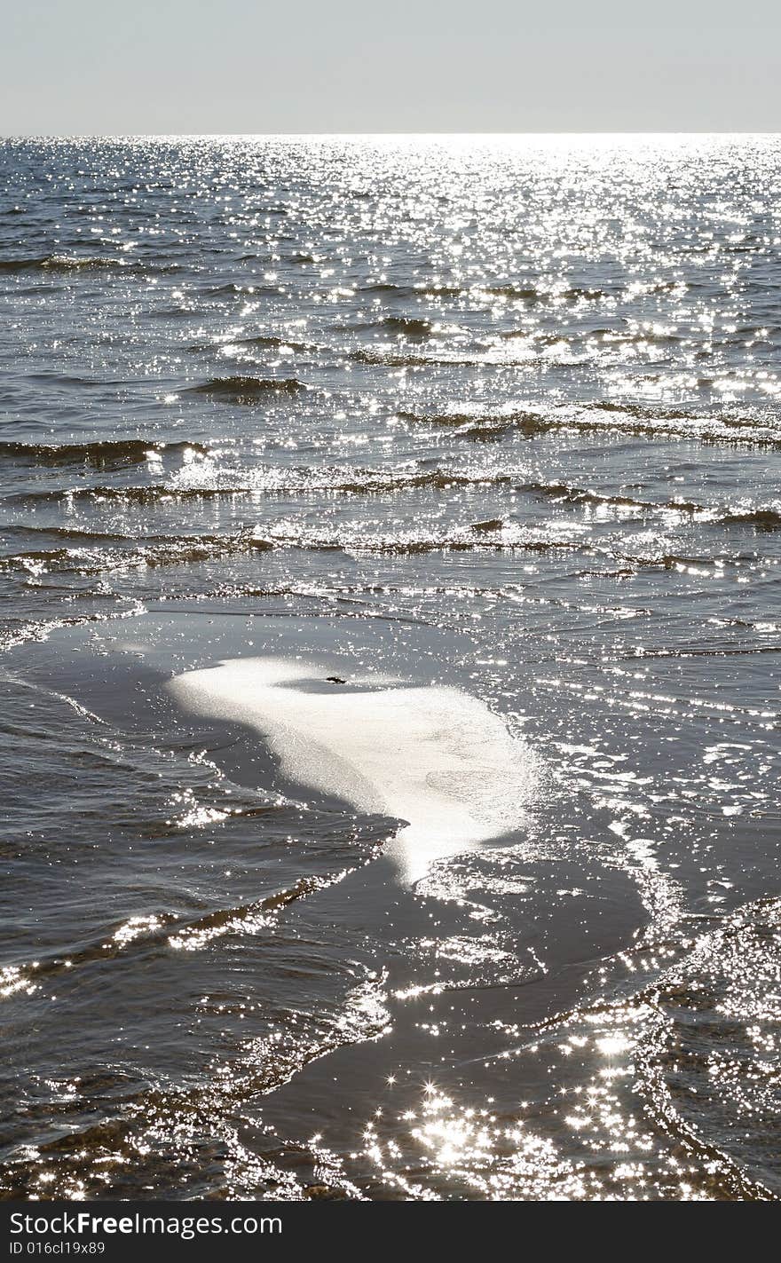 Beach view of a sparkling water surface. Beach view of a sparkling water surface