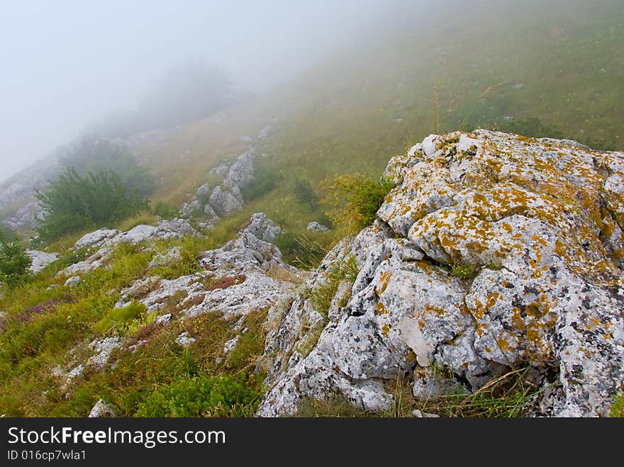 Misty morning meadow in Crimea mountains, Ukraine. Stones on a foreground