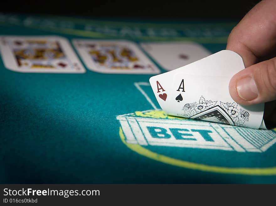 Poker game showing a full house, focus on the pair of aces.