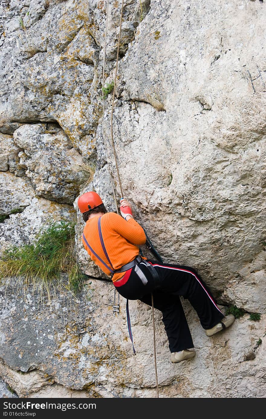 The climber rises upwards on a rock