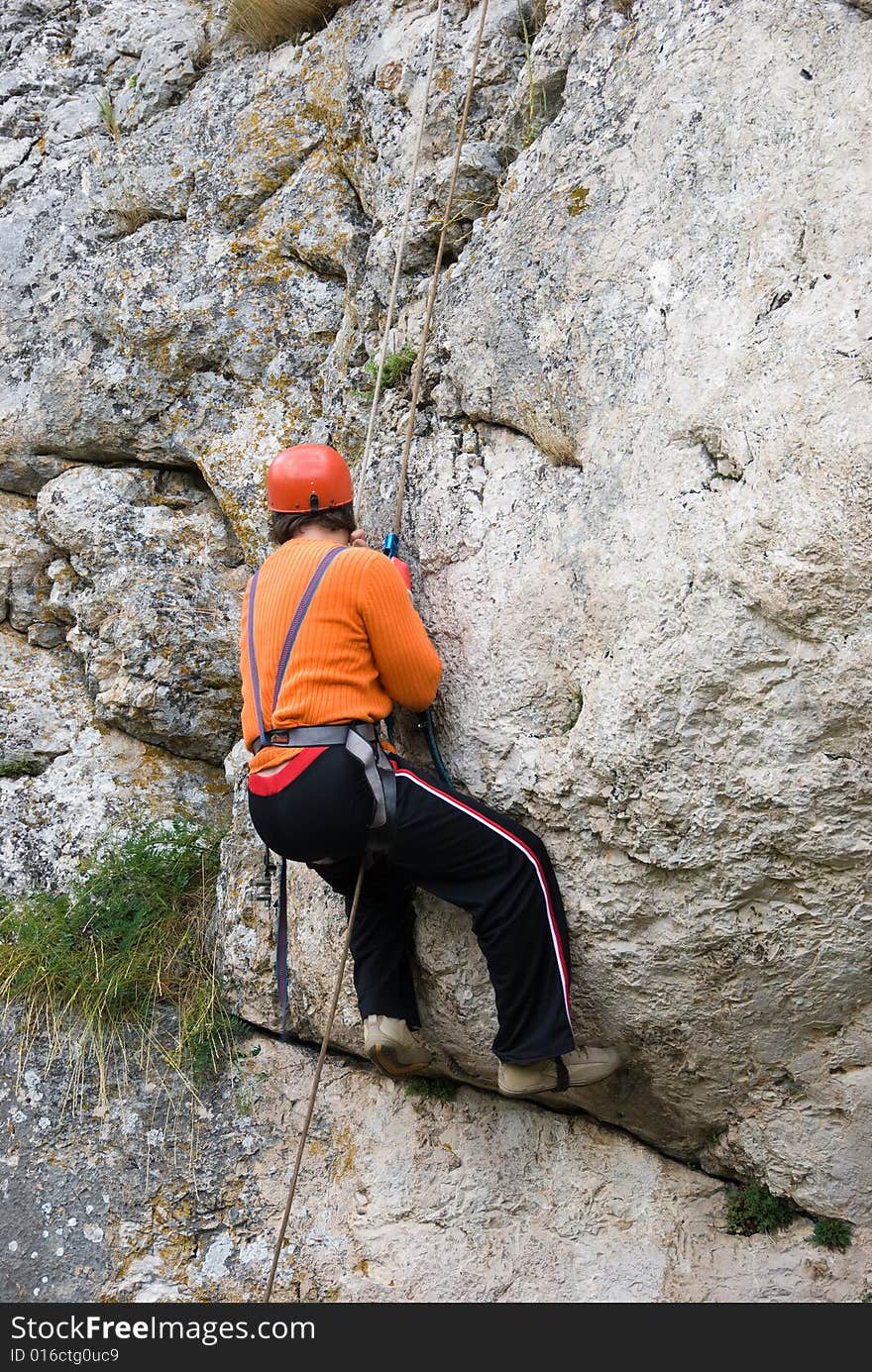 The climber rises upwards on a rock