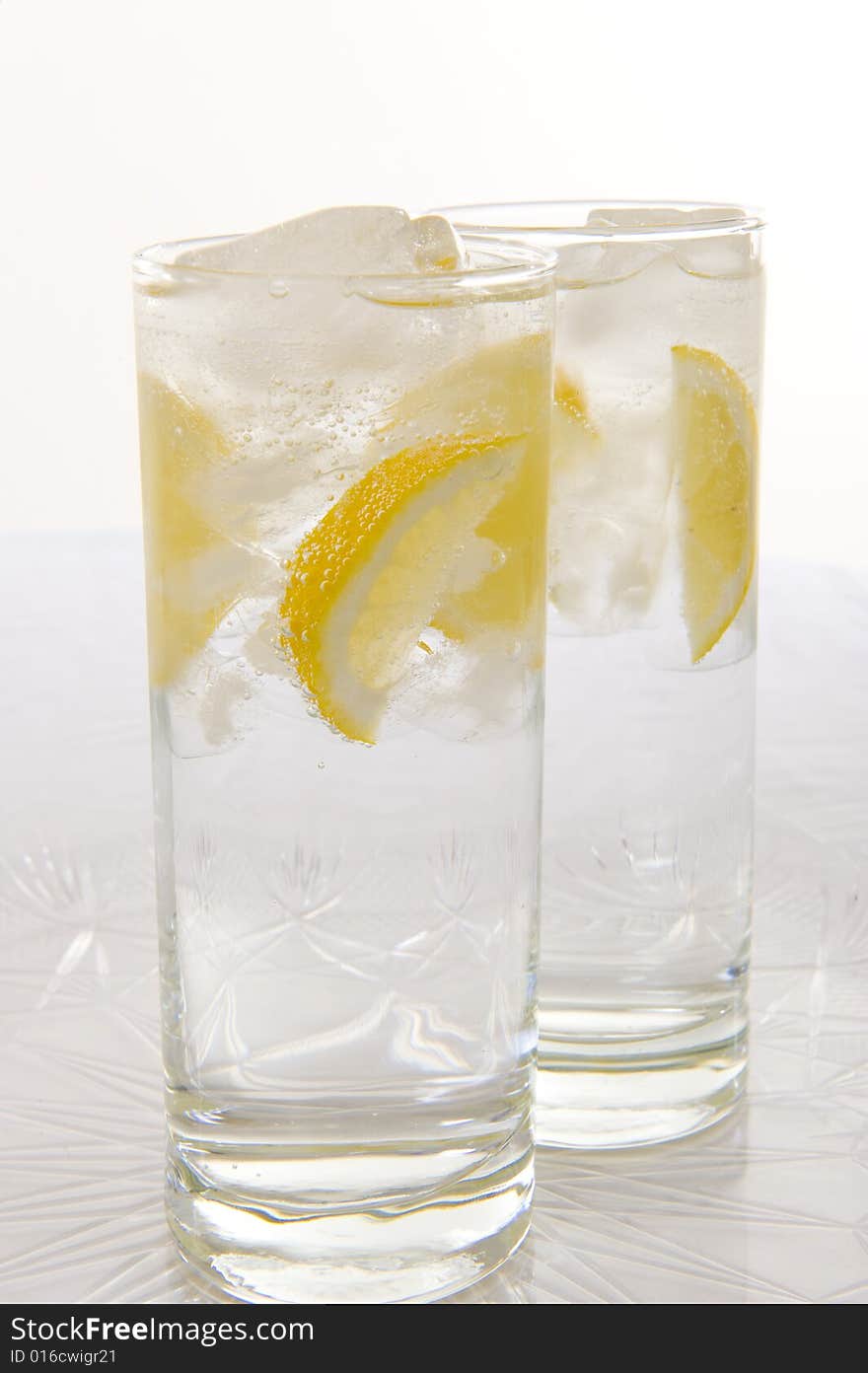 Sparkling water with slices of fresh lemon and lime on a white background. Sparkling water with slices of fresh lemon and lime on a white background.