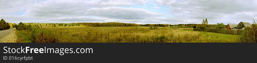 The sky in clouds over little village, on a background the mixed wood. The sky in clouds over little village, on a background the mixed wood