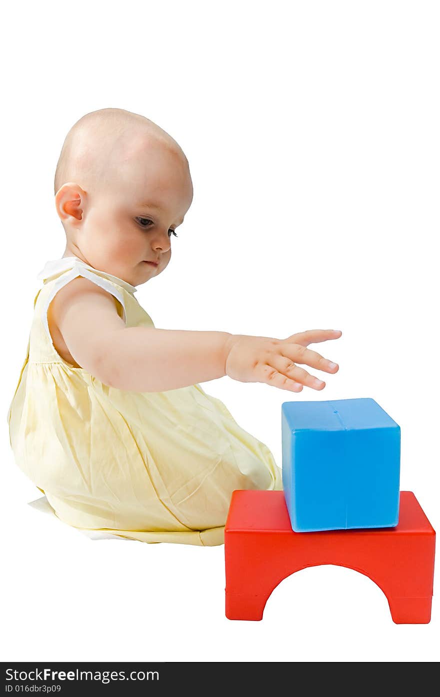 Little baby girl playing with her toys, building, isolated on white