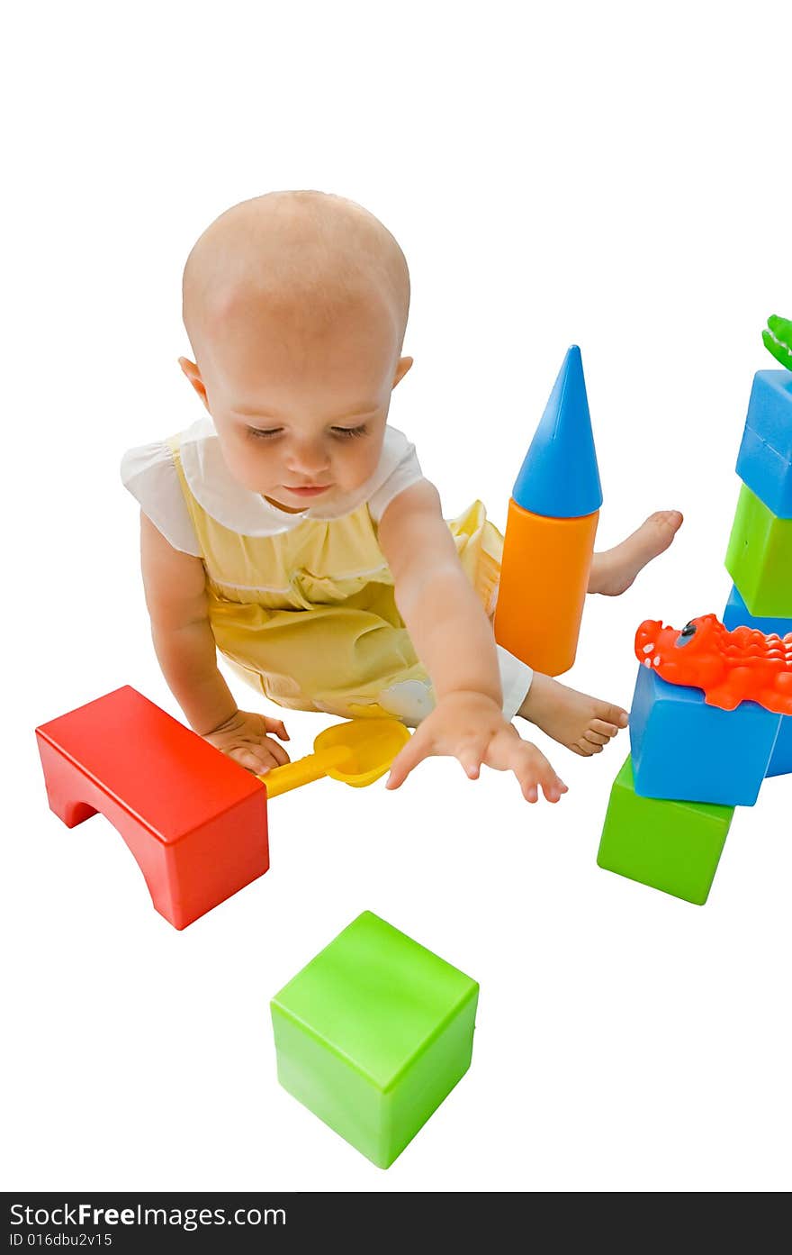 Little baby girl playing with her toys, isolated on white