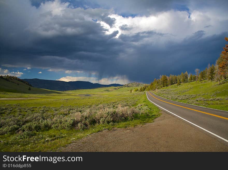 A road leading to a storm in Yellowstone National Park. A road leading to a storm in Yellowstone National Park